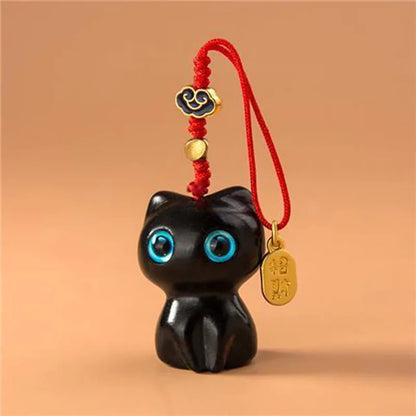 Bijou de téléphone chat en bois Mon Petit Grigri, modèle noir ébène yeux bleus avec fin cordon rouge