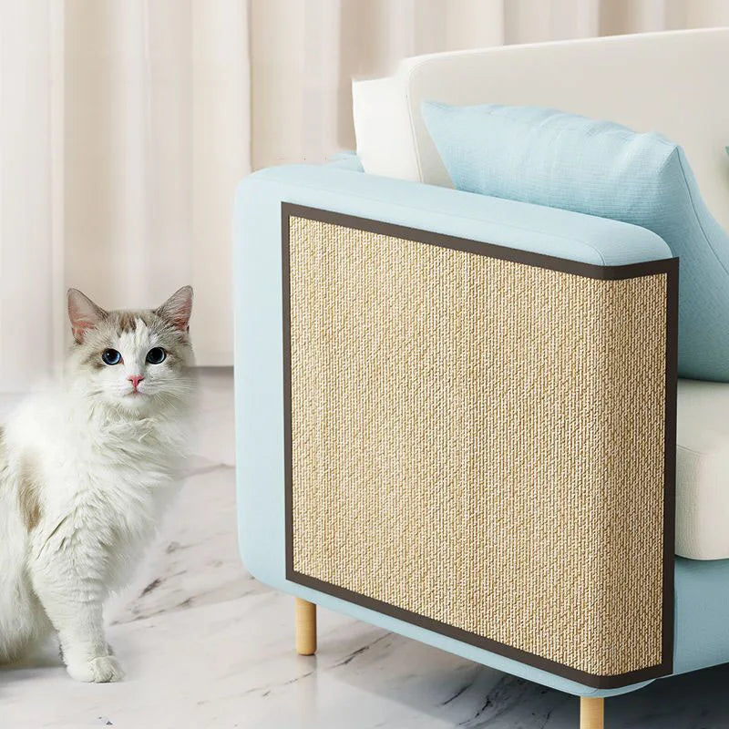 Griffoir protège-canapé pour chat en lamelles de bambou posé sur le flanc d'un accoudoir bleu clair, chat assis à côté