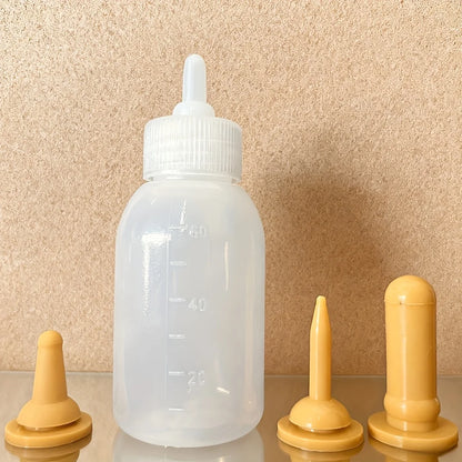 Biberon pour chaton 60 ml translucide, tétine montée, et ses trois tétines de rechange ambrées de formes différentes