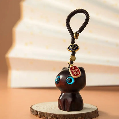 Porte-clés chat en bois Mon Petit Grigri posé sur une rondelle de bois, cordon tressé et perles de laiton doré