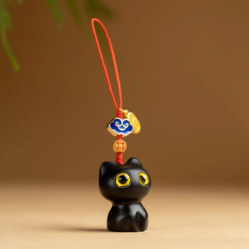 Bijou de téléphone chat en bois Mon Petit Grigri, modèle noir ébène yeux jaunes avec fin cordon rouge