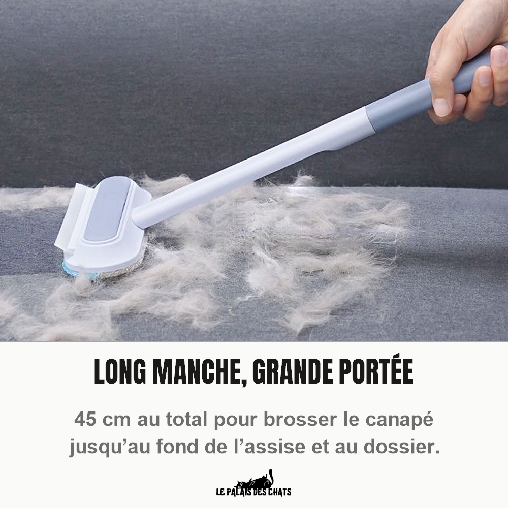 Brosse anti-poils à long manche passée sur un canapé gris couvert de poils