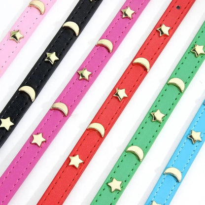 Gros plan sur les étoiles et lunes dorées du collier Majesté Céleste, en six coloris du rose au bleu turquoise