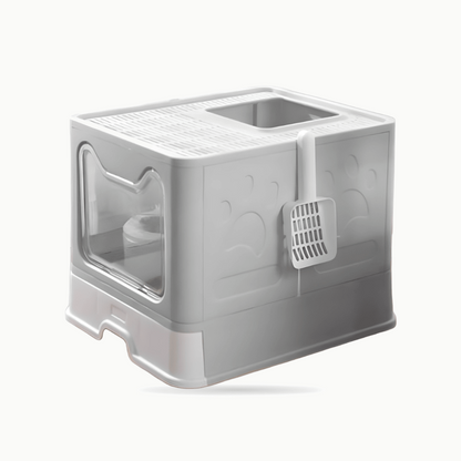 Maison de toilette grise fermée vue de trois quarts, porte transparente et pelle à litière accrochée sur le côté