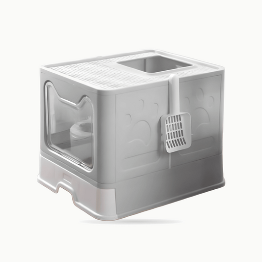 Maison de toilette grise fermée vue de trois quarts, porte transparente et pelle à litière accrochée sur le côté