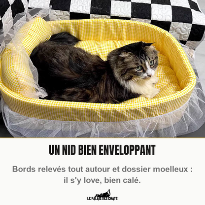 Chat tigré à poils longs lové dans le panier pour chat Le Boudoir Royal jaune citron, aux bords relevés et au volant de tulle
