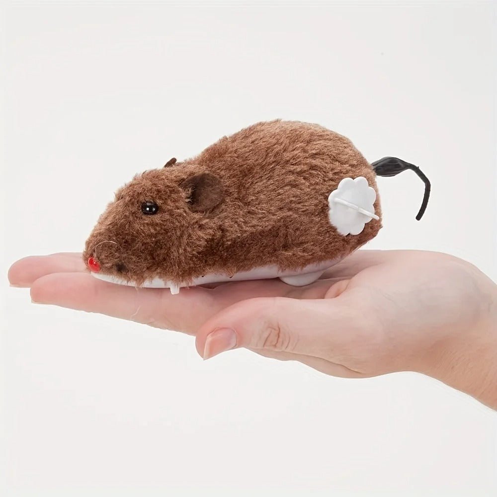 Souris à remonter Ratatouille brune posée dans une main, remontoir blanc sur le flanc