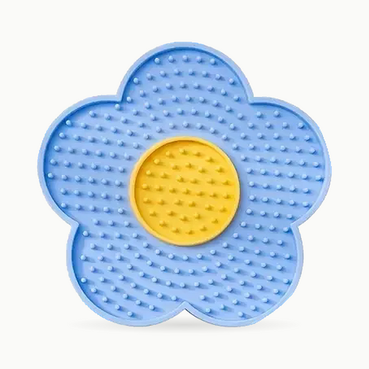 Tapis de léchage pour chat en silicone bleu en forme de fleur, couvert de picots, avec son cœur jaune, vu de face